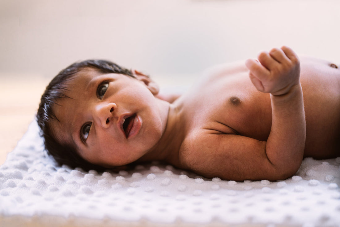 Image of a newborn baby on its back, staring upward