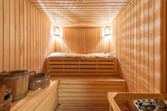 Image of a sauna with bench of metal buckets. Wood interior sauna.
