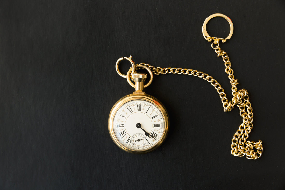 Image of gold pocketwatch against black backround