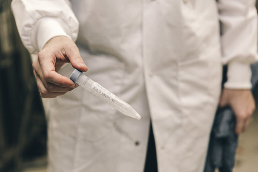 Image of person in lab coat holding a test tube