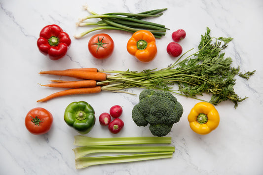 Image of fresh vegetables on white background. Bell peppers, celery, peppers, carrots, broccoli, radish, tomatoes