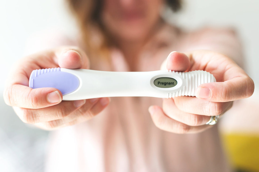 Image of female holding a pregnancy test